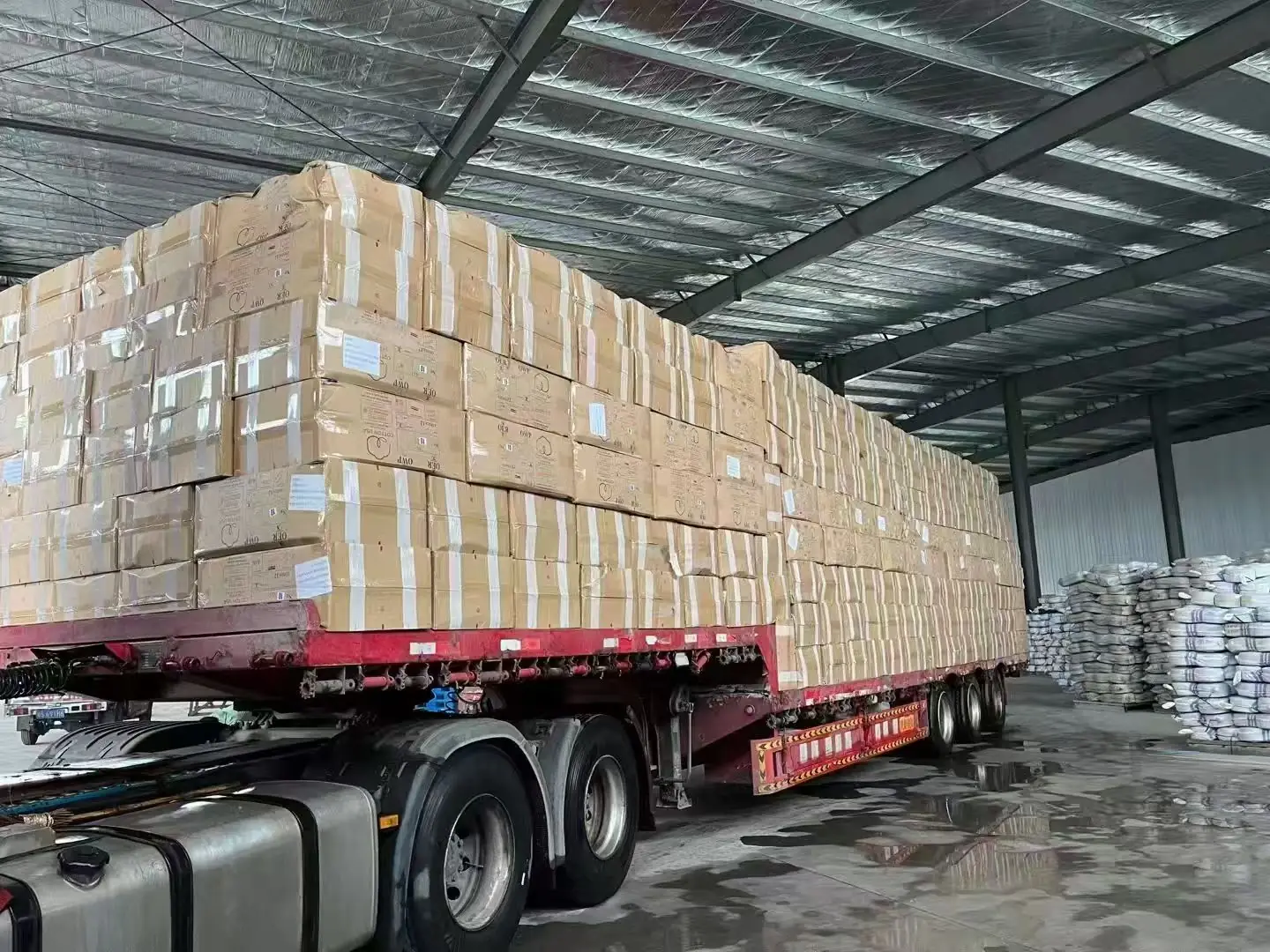 Flatbed trailer fully loaded with cartons at China warehouse for land freight