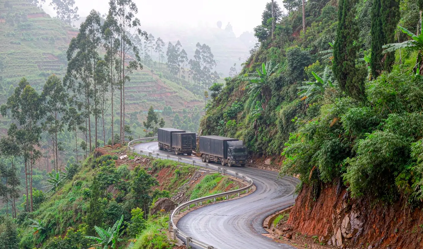 Container trucks climbing a winding road through tropical highlands - inland delivery from Toamasina to Antananarivo by CargoSolid