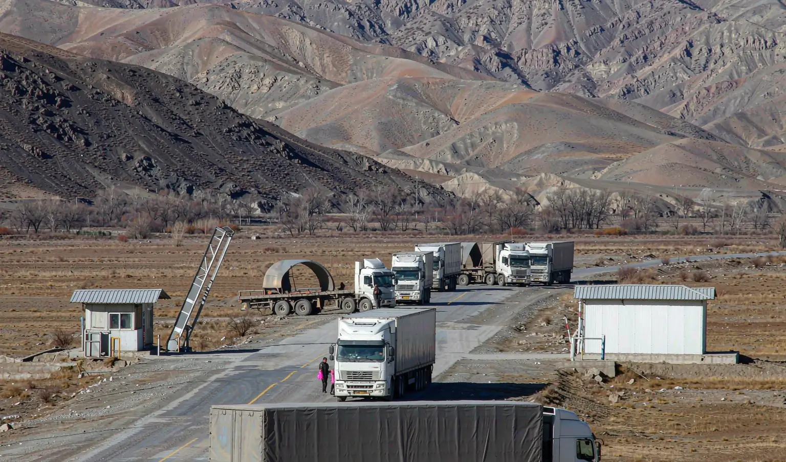 Queue of long-haul trucks at a mountain border crossing in Central Asia - land transport alternative to ocean chokepoints by CargoSolid